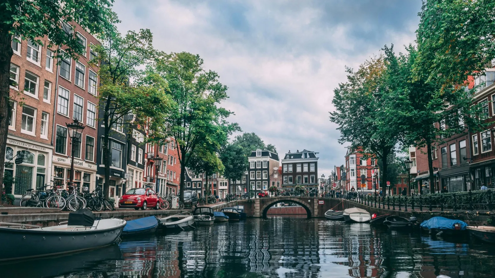 Canal-side street with small businesses in Amsterdam